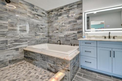 a bathroom with a tub and a sink and a mirror at Riverfront Port Orange Home with Dock and Slip! in Port Orange
