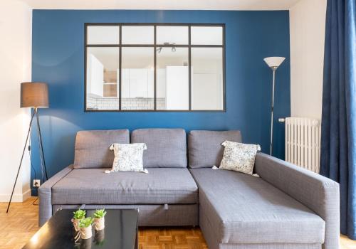 salon z niebieskimi ścianami i kanapą w obiekcie Annecy Liberty w Annecy