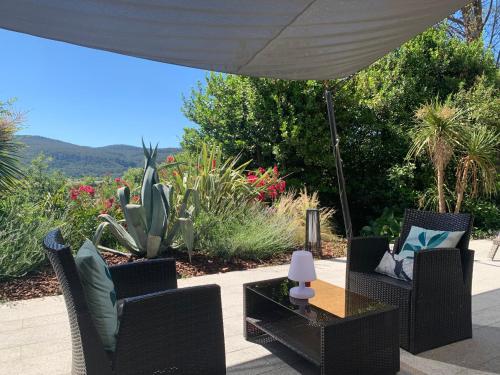 une terrasse avec deux chaises et une table avec un cactus dans l'établissement Gîte BALI - 2 à 4 pers., à Cuges-les-Pins