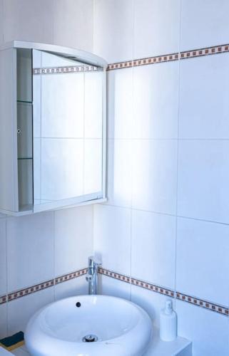 La salle de bains blanche est pourvue d'un lavabo et d'un miroir. dans l'établissement T2 aménagé Palais Longchamp, à Marseille