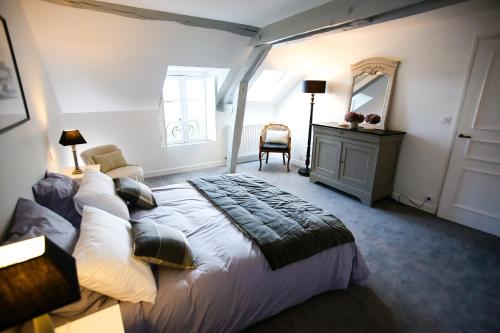 une chambre avec un grand lit et un miroir dans l'établissement L’Atelier, à Saint-Denis-sur-Loire
