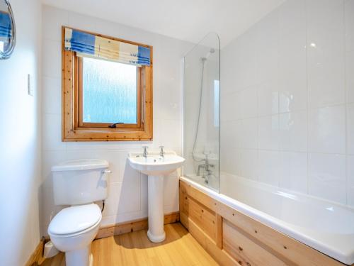uma casa de banho com um WC, um lavatório e uma banheira em Forest Lodge em Legbourne