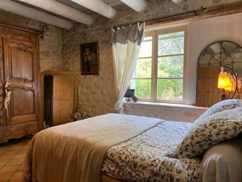 1 dormitorio con cama y ventana en Cottage chaleureux avec piscine privée, en Sainte Anastasie - Aubarne