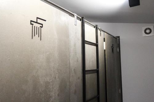 a bathroom with a shower stall with a sign on the wall at Hostel Pia do Urso in Batalha