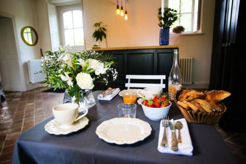 une table avec un chiffon de table bleu, du pain et des fleurs dans l'établissement L’Atelier, à Saint-Denis-sur-Loire