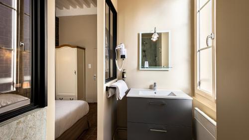 a bathroom with a sink and a mirror at Logis Hostellerie Bressane in Saint-Germain-du-Bois