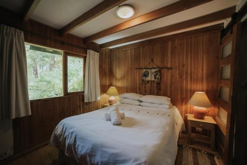 a bedroom with a bed with two towels on it at Cabañas Metreñehue - Parque Metreñehue in Pucón