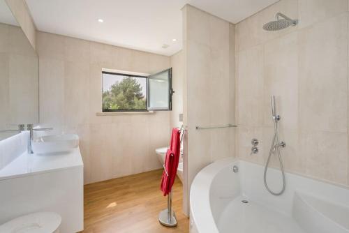 a bathroom with a tub and a toilet and a sink at Wonderful Villa near Lisbon in São Domingos de Rana