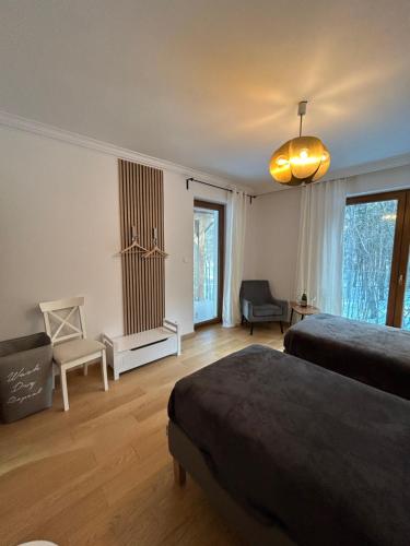 a bedroom with two beds and a large window at Leśna Residence & SPA in Pisz