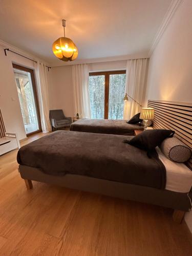 a large bedroom with two beds and a lamp at Leśna Residence & SPA in Pisz