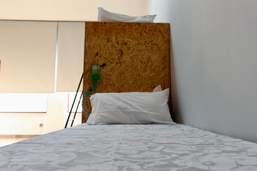 a bedroom with a bed with a wooden headboard at Hostel Pia do Urso in Batalha