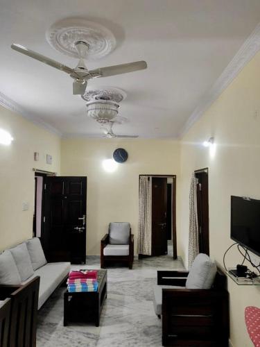 a living room with a couch and a ceiling fan at Home to explore Food, History & Shopping in Hyderabad