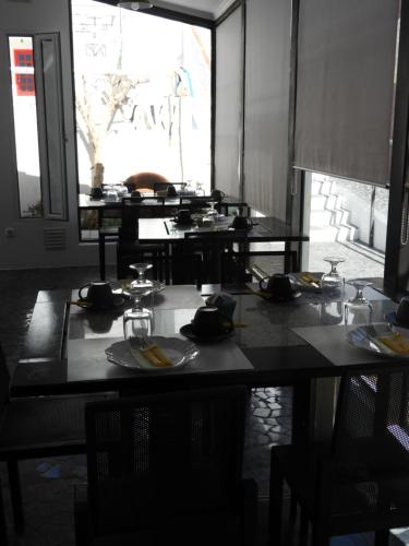 Un grupo de mesas en un restaurante con platos y vasos. en Alandroal Guest House, Hotel, en Alandroal