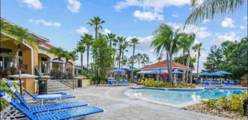 uma piscina num resort com cadeiras azuis e guarda-sóis em Terra Verde Resort em Kissimmee