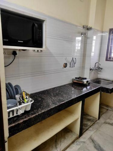 a kitchen with a counter with a sink and a microwave at Home to explore Food, History & Shopping in Hyderabad
