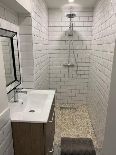 une salle de bain blanche avec un lavabo et une douche dans l'établissement L' Horloge, à Vézénobres