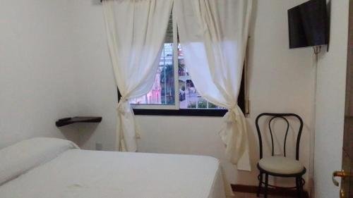 1 dormitorio con 1 cama, 1 silla y 1 ventana en Torre Central en San Salvador de Jujuy