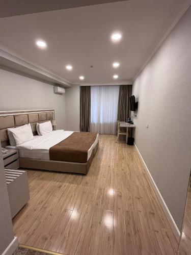 um quarto com uma cama e uma televisão em Grand Inn Baku Hotel em Baku