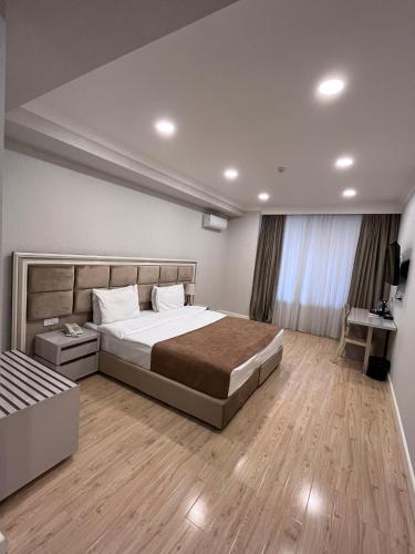 um quarto com uma cama grande e piso em madeira em Grand Inn Baku Hotel em Baku