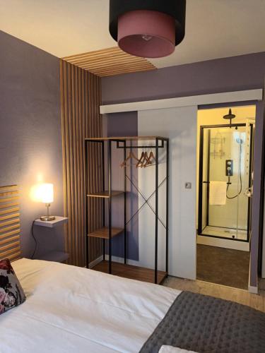 a hotel room with a bed and a mirror at Les chambres de la Vallée in Argenton-Château