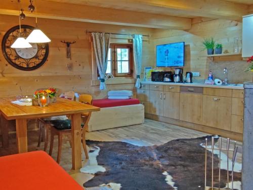 a living room with a table and a kitchen at Ferienwohnungen Anni im Paradies in Kiefersfelden