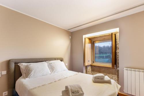 - une petite chambre avec un lit et une fenêtre dans l'établissement Sé Apartamentos - Casa da Rabeta, à Forjães