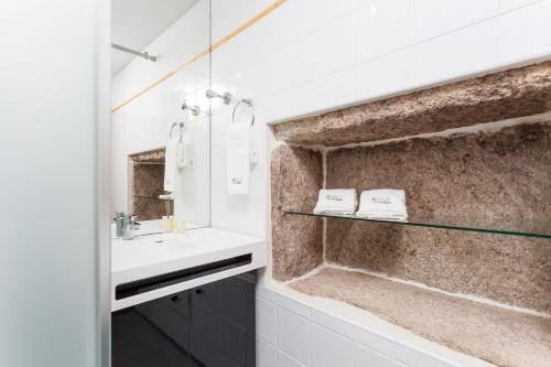 a bathroom with a sink and a mirror at Sé Apartamentos - Casa da Rabeta in Forjãis