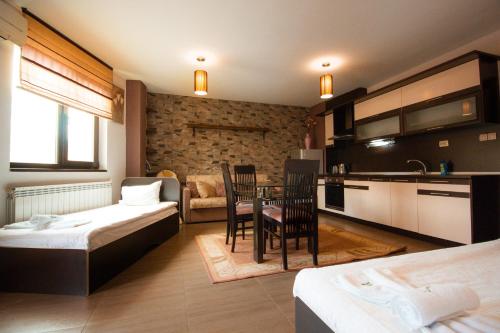 a room with two beds and a table and a kitchen at SPA Apartments Perun in Sandanski