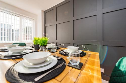 tavolo da pranzo con ciotole e piatti bianchi di Premium 4 Bed Detached in Heswall a Heswall