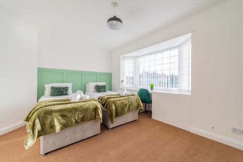 赫斯華爾的住宿－Premium 4 Bed Detached in Heswall，一间卧室设有两张床和窗户。