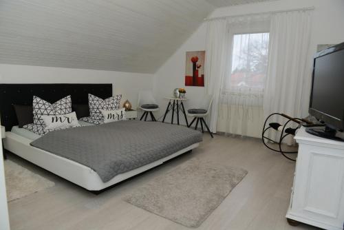 1 dormitorio con 1 cama grande y TV en Sommerhaus, en Veszprém