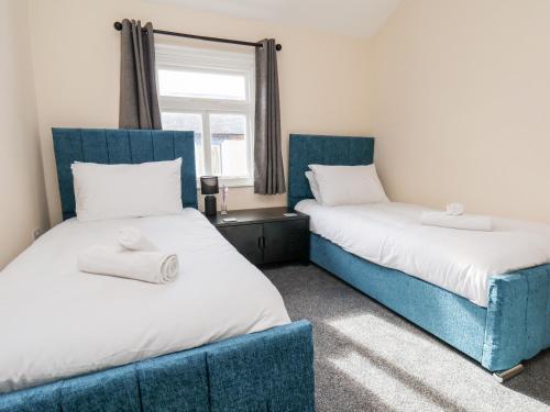2 Betten mit blauen Stühlen in einem Zimmer in der Unterkunft 46 St Mary's Walk in Scarborough