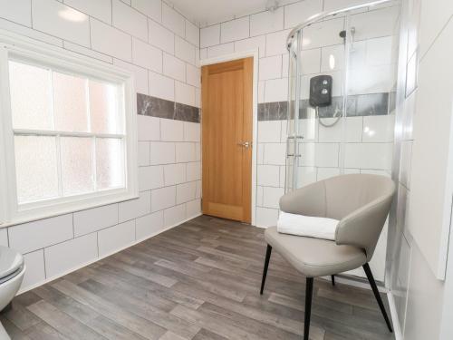 ein Bad mit einer Dusche, einem Stuhl und einem WC in der Unterkunft 46 St Mary's Walk in Scarborough