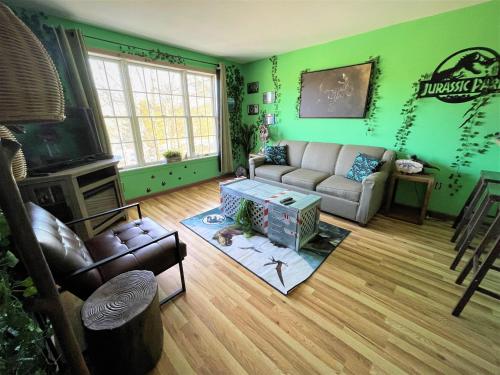 a living room with green walls and a couch and a tv at Jurassic Dino Suite Jiminy-Must See Sleeps 4 in Hancock