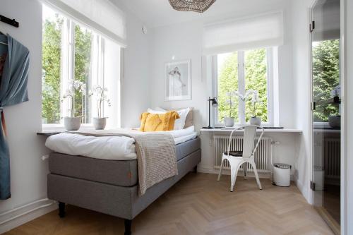 a bedroom with a bed and two windows at WOW, Föreningsgatan 9 in Gothenburg