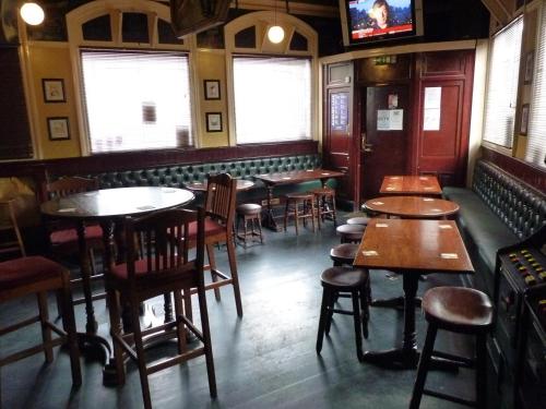 a room with tables and chairs in a restaurant at Shanahans B&B with Sports Bar in Birmingham