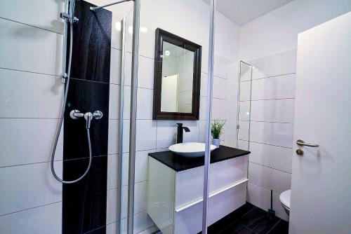 een witte badkamer met een wastafel en een spiegel bij Haus Frauenpreiss F502 in Cuxhaven