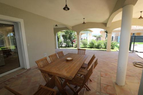 une salle à manger avec une table et des chaises en bois dans l'établissement Magnifique Rez de jardin à 150 M de la mer, à Sainte-Maxime