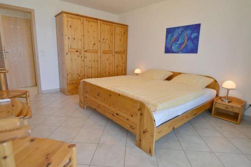 um quarto com uma grande cama de madeira num quarto em Haus Horizont H513 em Cuxhaven
