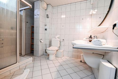 uma casa de banho com um WC, um lavatório e um chuveiro em Haus Horizont H513 em Cuxhaven