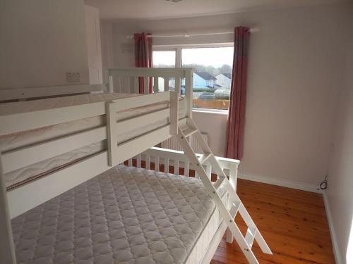 a bunk bed in a room with a window at Kool 12 bed house in Letterkenny TowN in Letterkenny