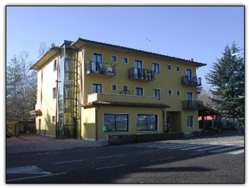 a large yellow building on the side of a street at Albergo Villa Eva in Costermano sul Garda