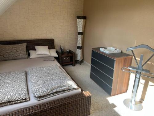 ein Schlafzimmer mit einem Bett, einer Kommode und einem Tisch in der Unterkunft 40 m2 Dachgeschosswohnung in Paderborn