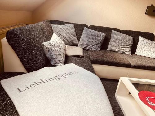 a living room with a couch with pillows at 40 m2 Dachgeschosswohnung in Paderborn