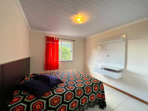 1 dormitorio con 1 cama con cortina roja en Chamego em Teresópolis próximo a feirinha, en Teresópolis
