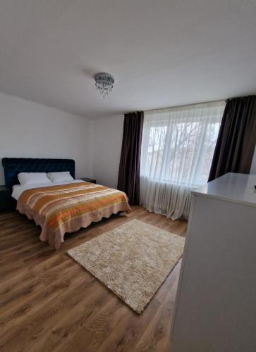 a bedroom with a bed and a large window at PREFECTURE APARTMENTS in Timişoara
