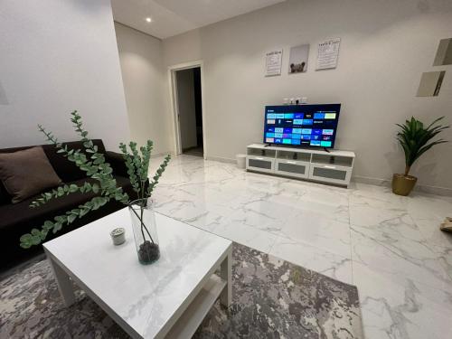 a living room with a couch and a tv at 3 Bedroom Apartment in Riyadh