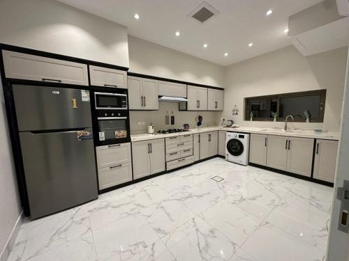 a large kitchen with white cabinets and appliances at 3 Bedroom Apartment in Riyadh