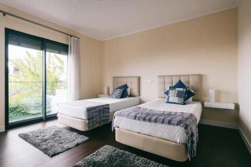 1 dormitorio con 2 camas y ventana grande en Casa Branca en Funchal