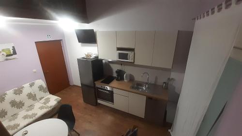 Apartments Mirjana في راب: مطبخ صغير مع أريكة وميكروويف